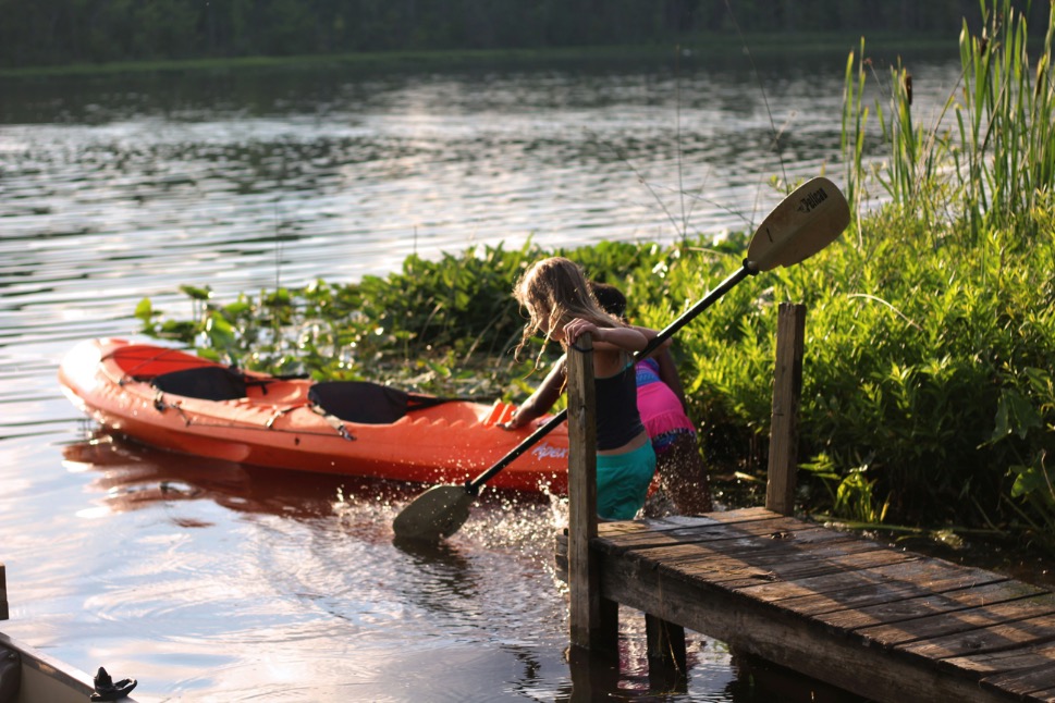 Image of a skilled kayak instructor providing lessons to children, promoting outdoor adventure and water safety education