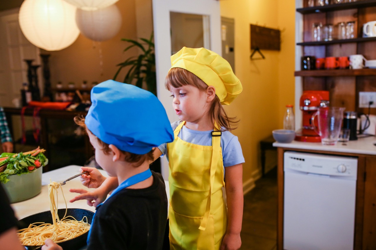 Image of a culinary expert teaching children cooking skills, fostering culinary education, and promoting fun and interactive culinary experiences