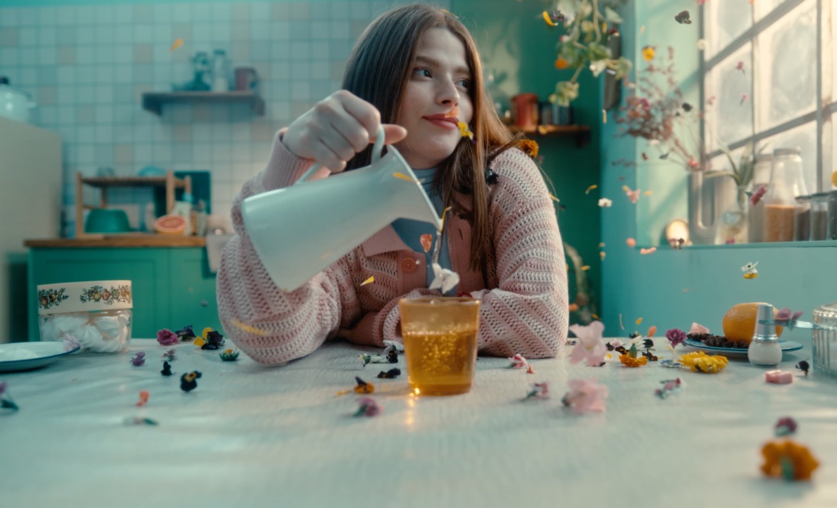 Woman enjoying a cup of tea with floating flowers in a dreamy, serene setting