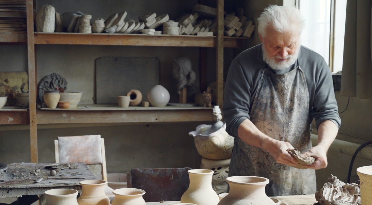 Atelier of an elderly potter filled with handcrafted pottery and traditional tools