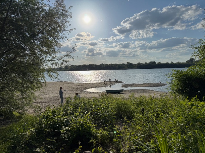 Families enjoying beach games and water activities at a lakeside setting