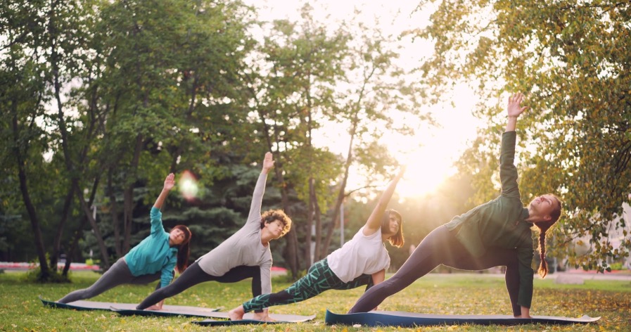 Group doing gentle stretches at sunset