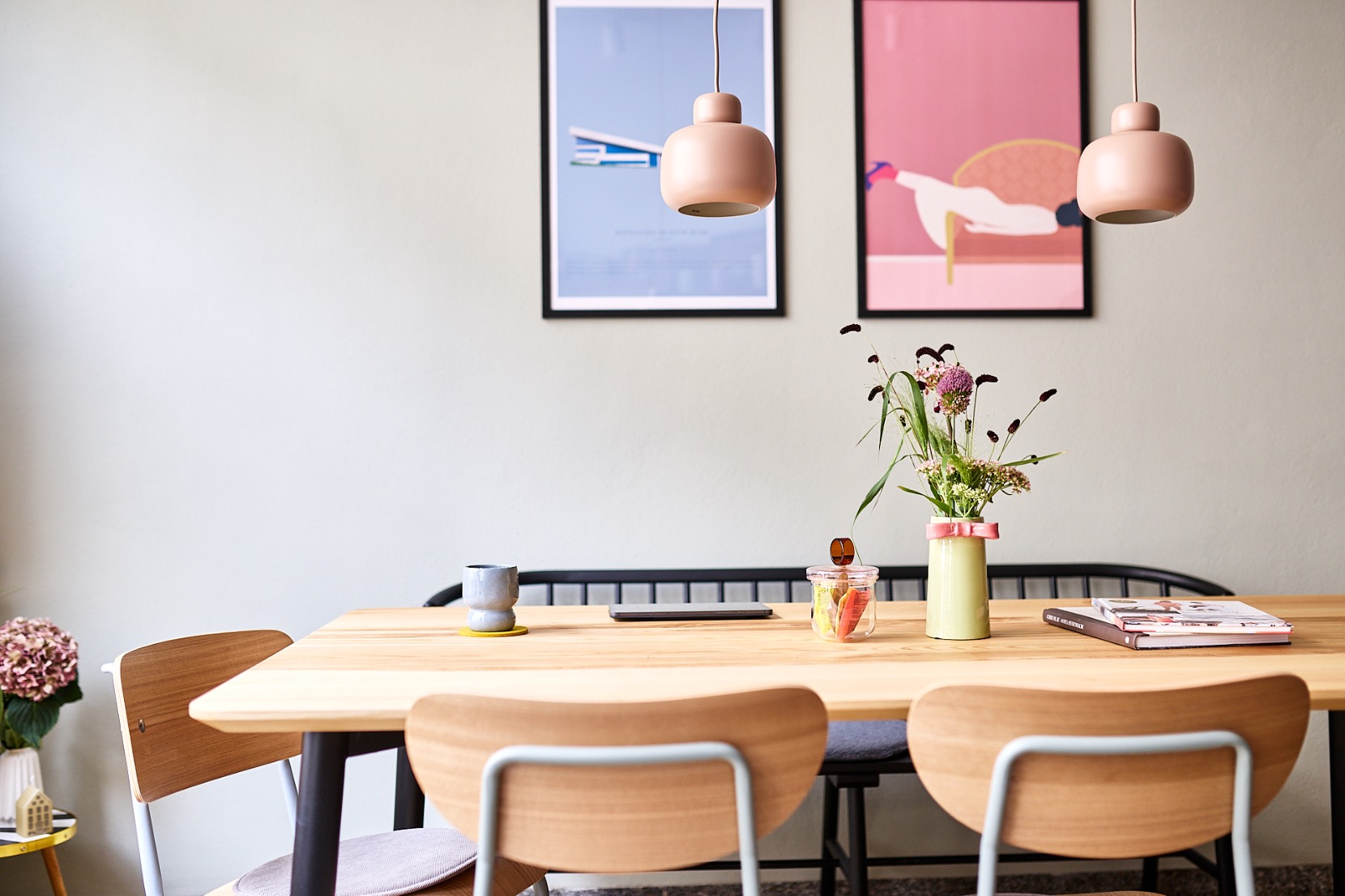 Ein heller Tisch mit Stühlen, Blumen und kleinen Snacks im Hygge Concept Store