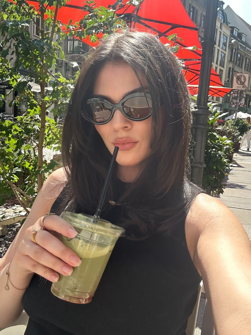 Franzi with a green drink at an outdoor café