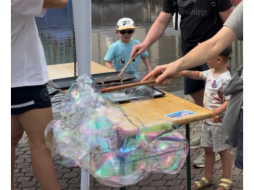 Bunte riesige Seifenblase vor dem Wasserbecken auf dem Leipziger Kinderfestival
