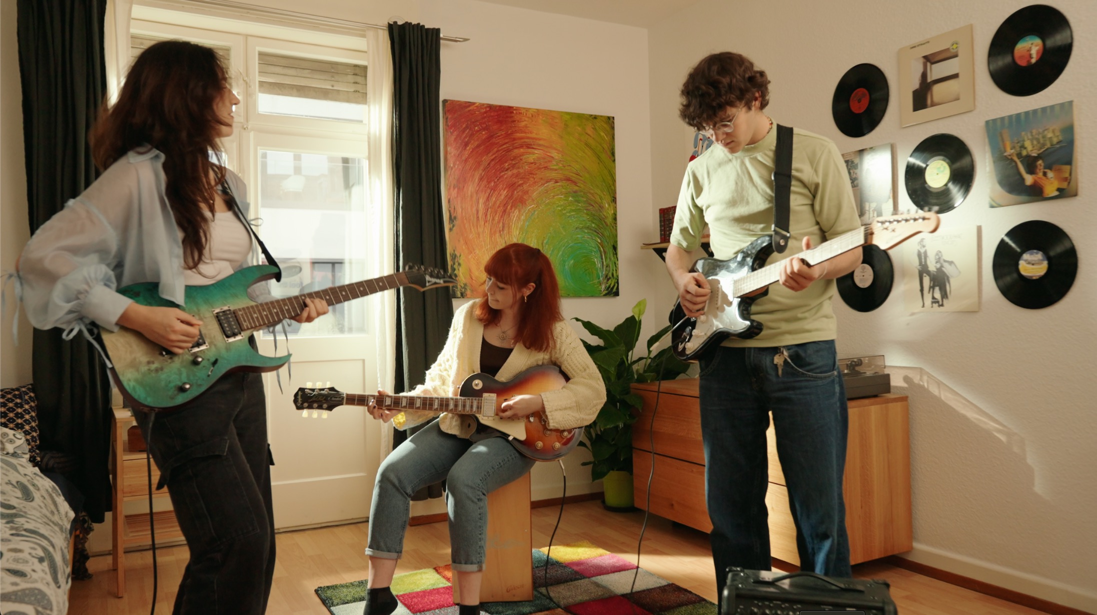 Drei junge Menschen spielen bei einer Jam-Session gemeinsam Gitarre