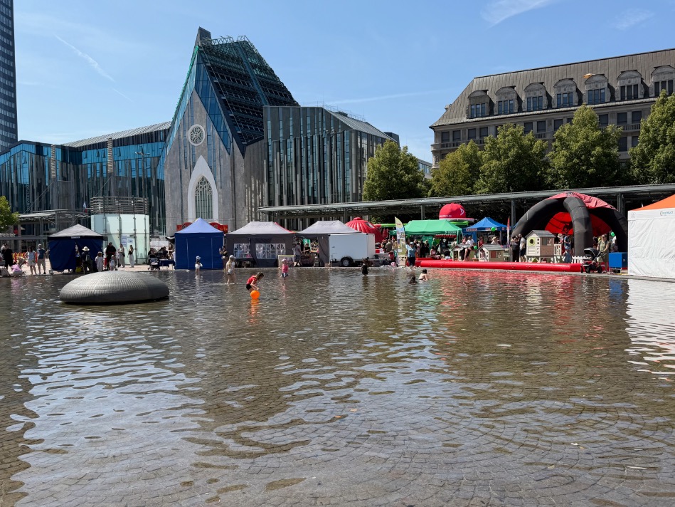 Wasserfläche und Stände beim Kinderfestival auf dem Leipziger Augustusplatz im Juli 2026, wo 99active mit Kindern Seifenblasen machte und von ihnen lernte, wie riesige Seifenblasen gelingen